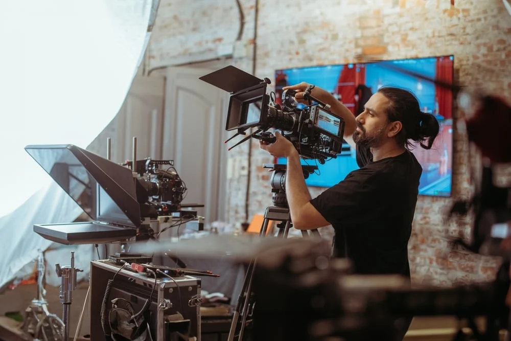 Filmmaker adjusting a professional camera on a video production set